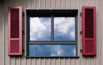 Hausfassade mit klassischen Klappläden vor den Fenstern