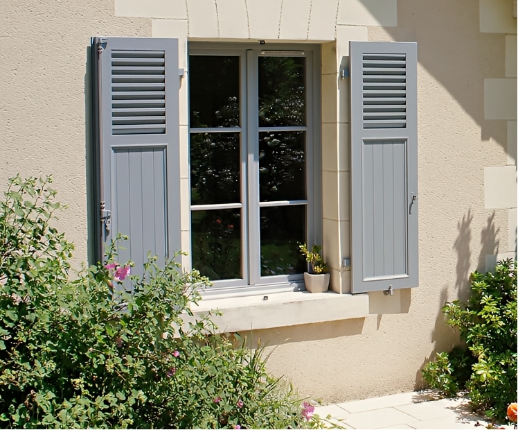 Hausfassade mit farbigen Fensterläden