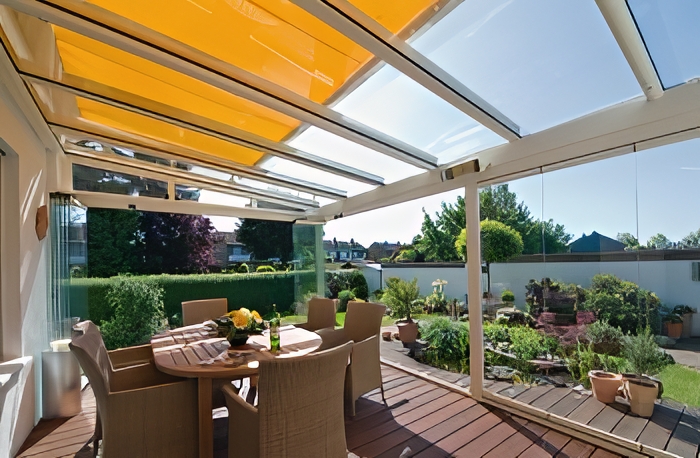 Terrassenüberdachung über einer gemütlichen Sitzgruppe im Garten