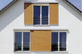 Moderne Hausfassade mit großen Schiebeläden vor den Fenstern