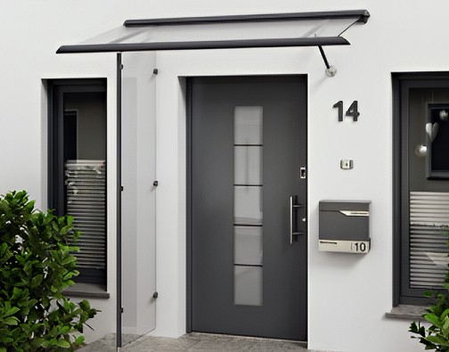 Aluminium-Vordach mit Glas und mit seitlichem Glaselement, das den Eingangsbereich zusätzlich vor Wind und Schlagregen schützt.