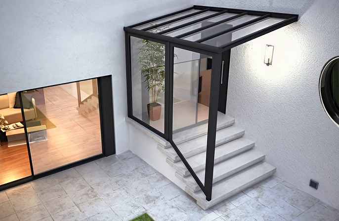 Aluminiumvordach als Pultdach mit Glas und einer senkrechten Glaswand im Bereich des Treppenpodests und der Treppe.