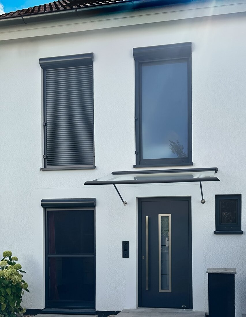 Aluminium-Glas-Vordach mit zwei Konsolen an Hausfassade