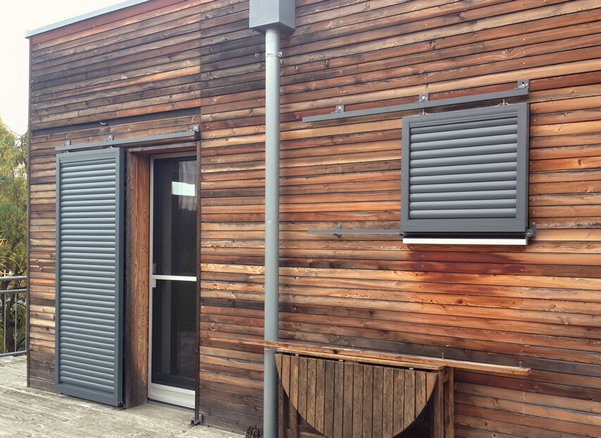 Aluminium-Schiebeläden auf Holzfassade